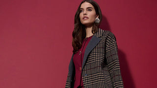 Woman wearing a Joseph Ribkoff plaid coat over a red outfit against a red background